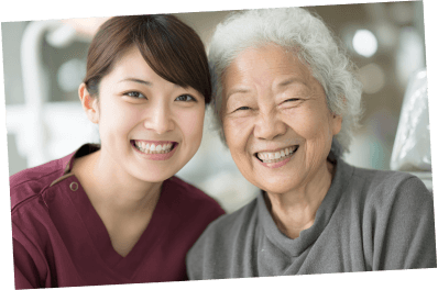キレイな歯を見せて笑っている高齢女性と歯科衛生士