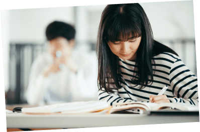 ノートに書き込んでいる勉強している女子学生